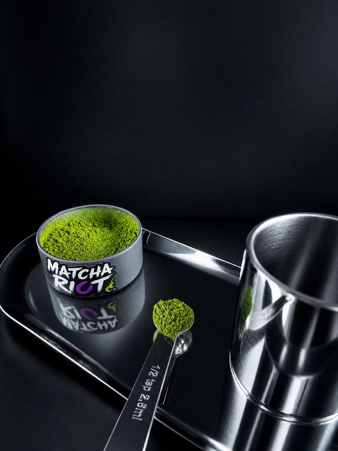 Open Matcha Riot tin with vibrant matcha and measuring scoop